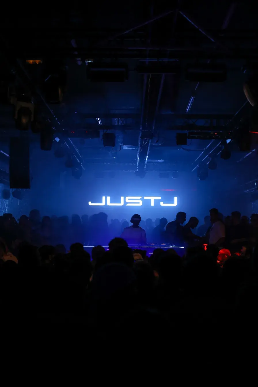 JUSTJ stage sign glowing blue